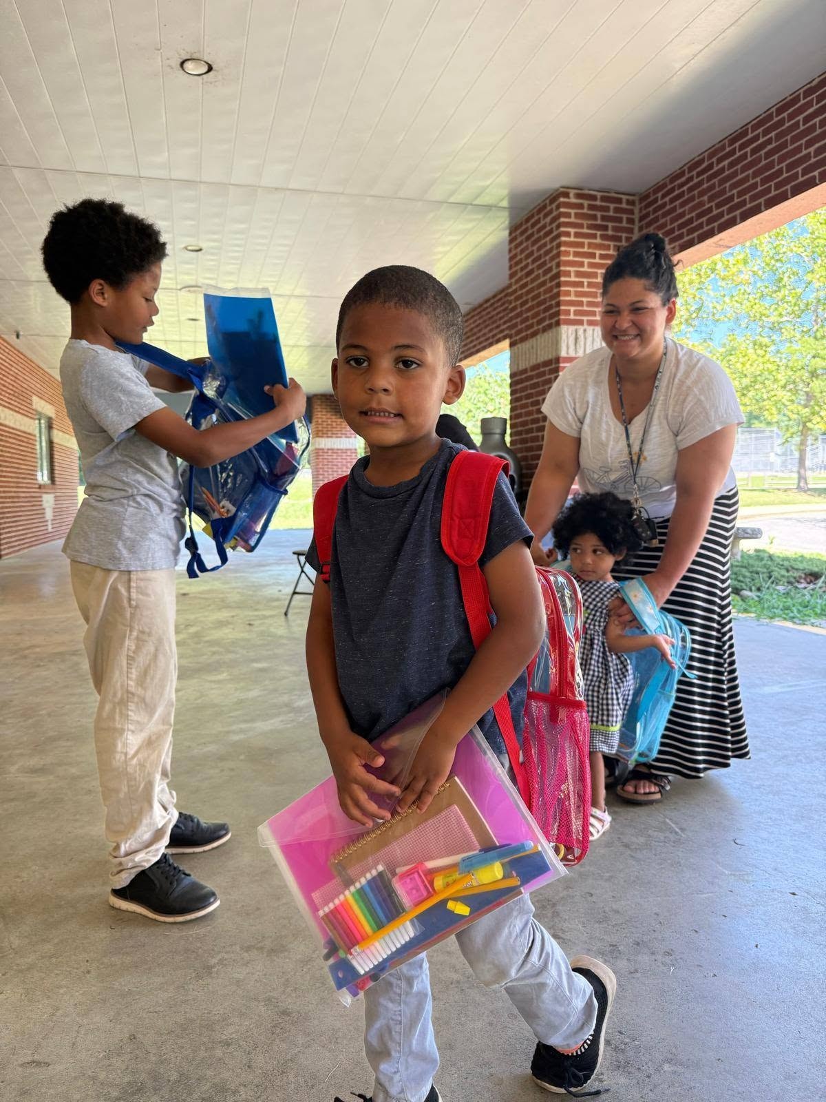 Child holding school supply kit at Back to School Community Bash August 2025