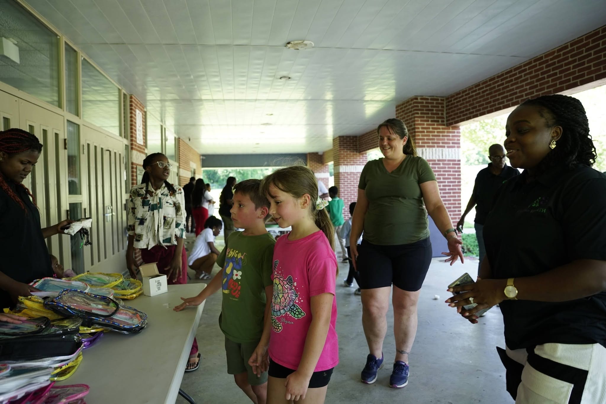 Families and children receiving supplies at distribution table