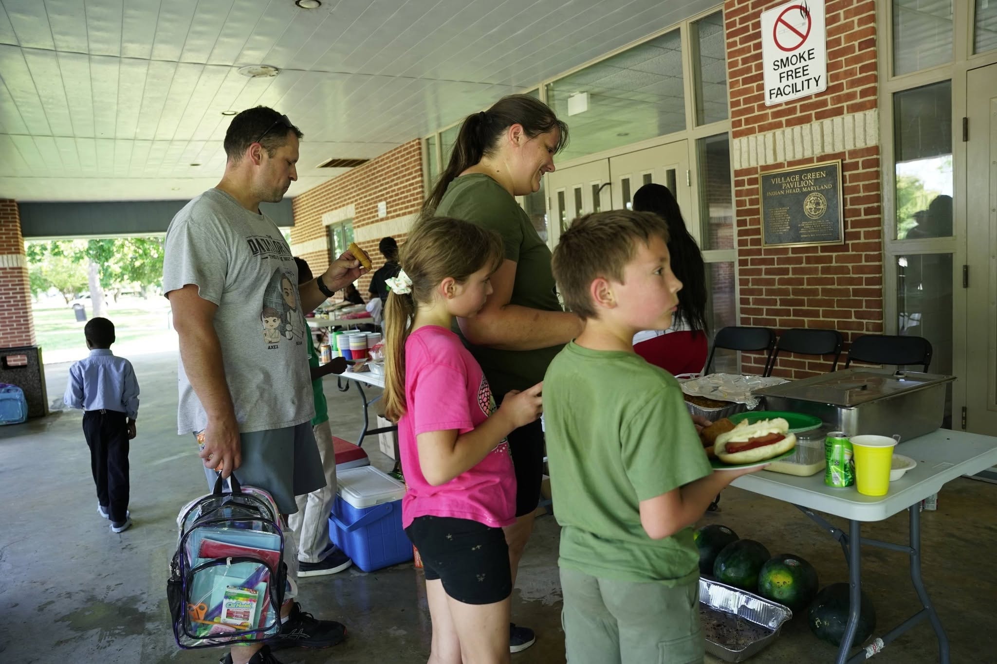 Volunteers serving food to families at Back to School Community Bash